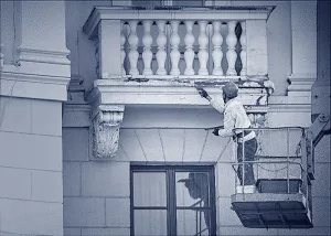 Ein Stuckateur bei der Arbeit an einem Balkon.