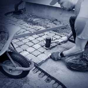 Ein Pflasterer beim Verlegen von Granitsteinen.